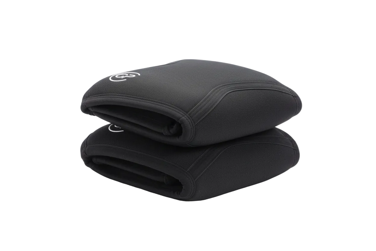 Pair of black knee pads with a logo on a beige surface