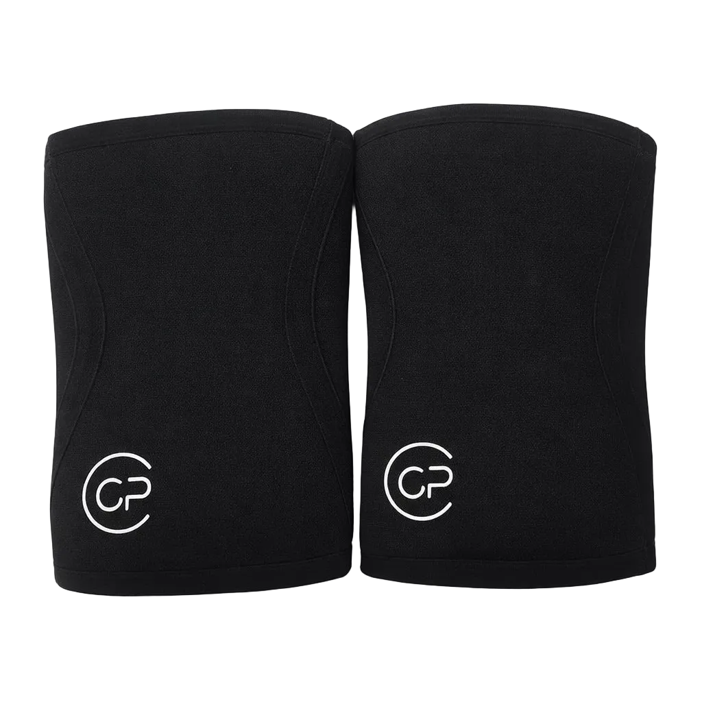 Two black knee pads with a logo on a light gray background
